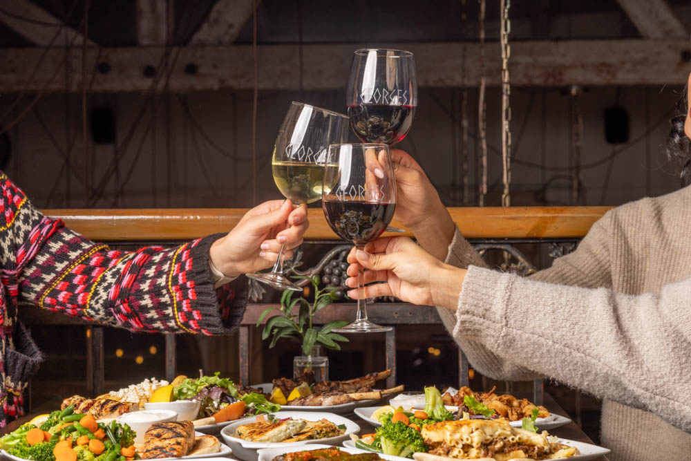 A toast over a table of Greek food